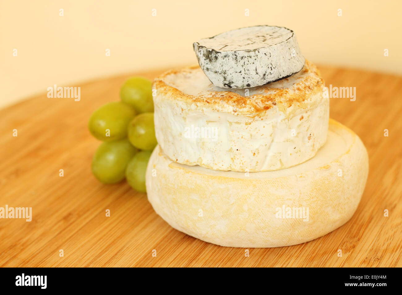 Pila di formaggio camembert e uva sulla tavola di legno Foto Stock