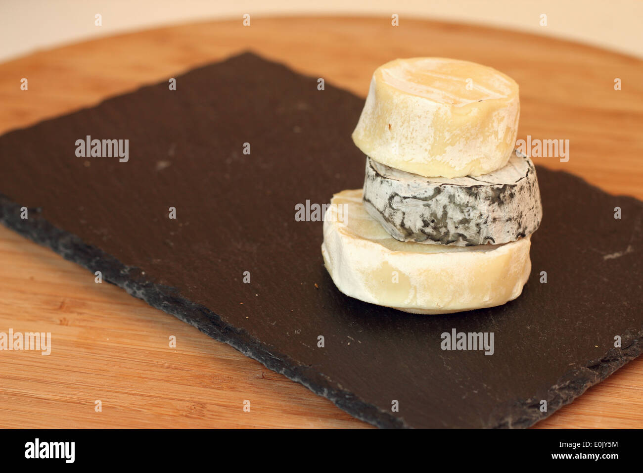 Pila di formaggio camembert sulla lastra di pietra sul tavolo di legno Foto Stock