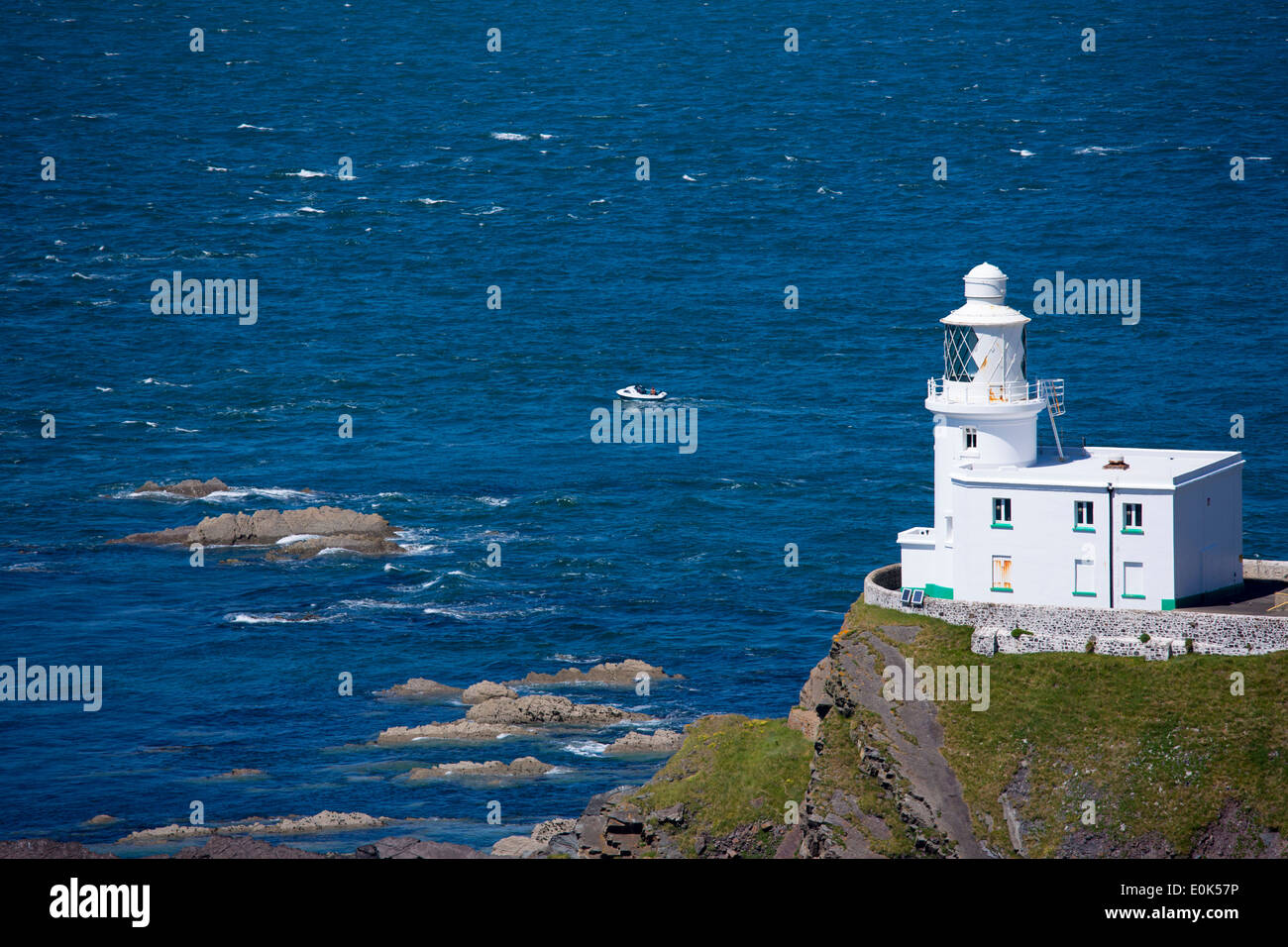 Speedboat passa Hartland Point Lighthouse, secolo XIX Il Grade ii Listed, Oceano Atlantico e del canale di Bristol nel nord-ovest del Devon Foto Stock