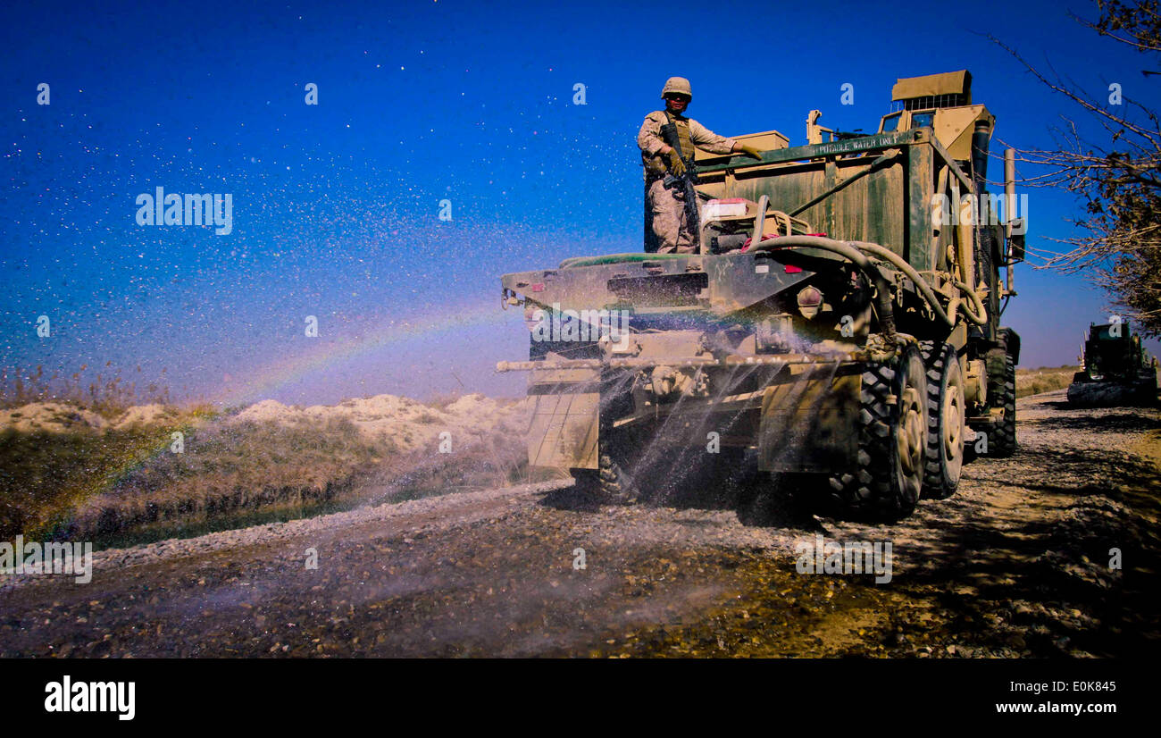 Marines con società di ingegnere, combattere il battaglione della logistica 3, 1° Marine Logistics Group (Avanti) saturare la strada con acqua Foto Stock