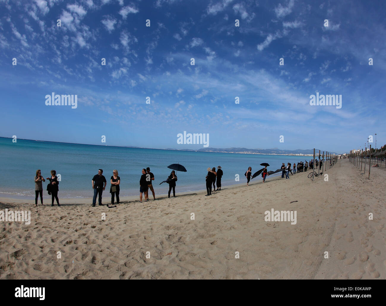 I turisti a prendere il sole sulla spiaggia a reagire come attivisti vestita di nero e di come i diavoli protestare contro l'olio prospections nell'area Foto Stock