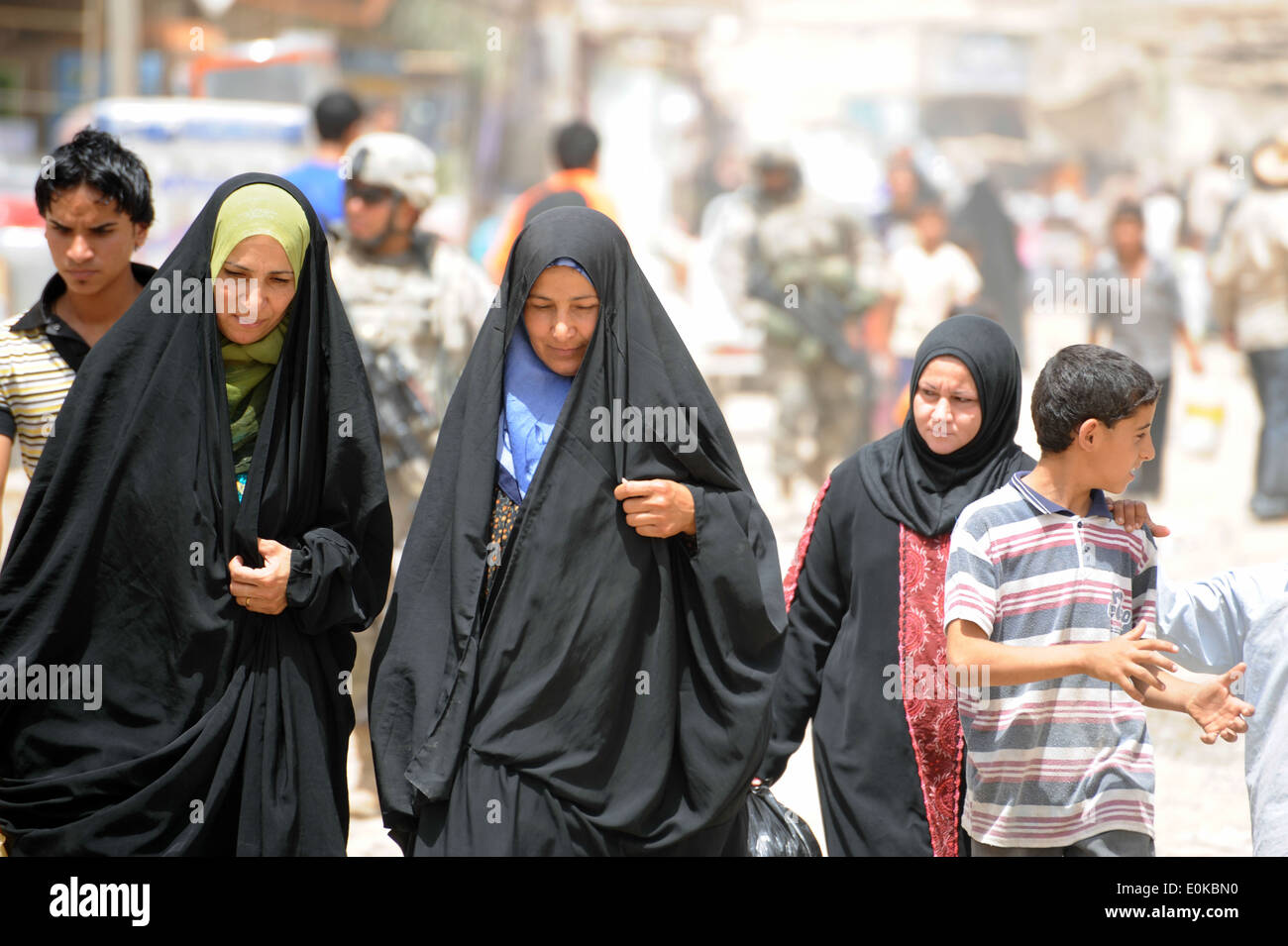 Le donne irachene a piedi verso il basso una trafficata strada del mercato di Bagdad orientale, Iraq, 21 giugno. Stati Uniti Soldati della società Alfa, 2° Battaglione, 5 Foto Stock