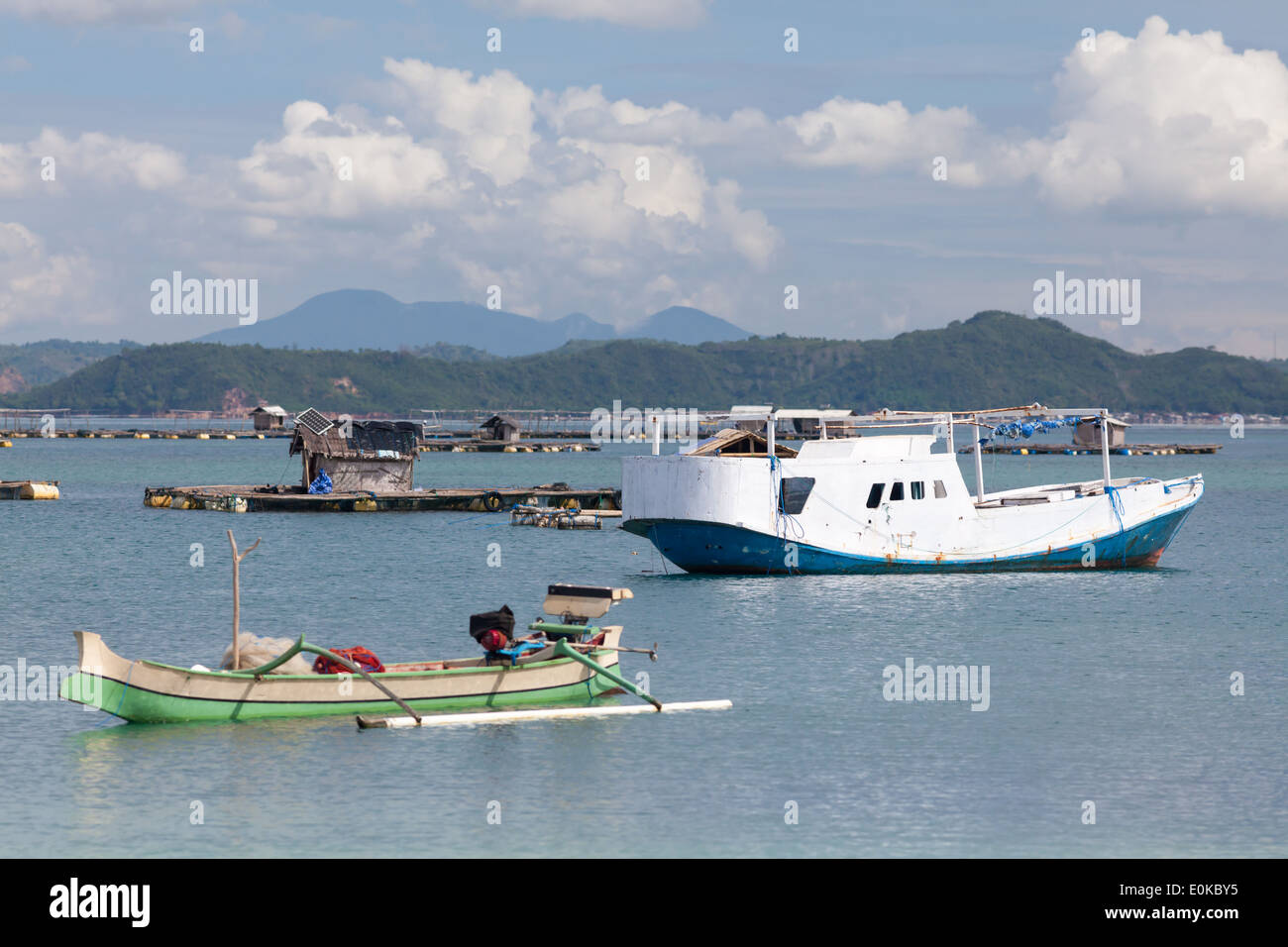 Barche e capanne flottante (utilizzato per far crescere i frutti di mare) - scenario della baia di Ekas, visto dalla regione di Ekas, Lombok, Indonesia Foto Stock