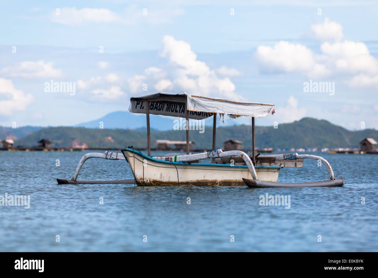 Barca e capanne flottante (utilizzato per far crescere i frutti di mare) - scenario della baia di Ekas, visto dalla regione di Ekas, Lombok, Indonesia Foto Stock