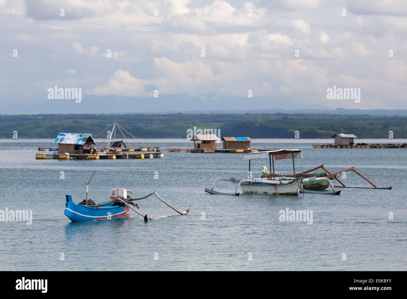 Barche e capanne flottante (utilizzato per far crescere i frutti di mare) - scenario della baia di Ekas, visto dalla regione di Ekas, Lombok, Indonesia Foto Stock