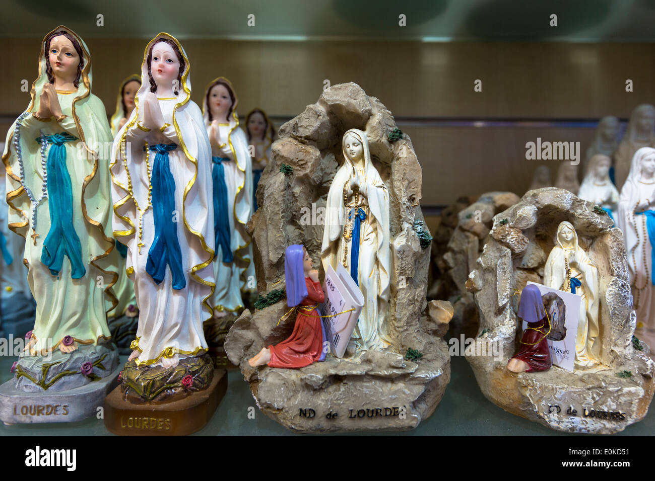 Icone Religiose e le statue della Madonna e di santa Bernadette al luogo di pellegrinaggio di Lourdes nel sud della Francia Foto Stock
