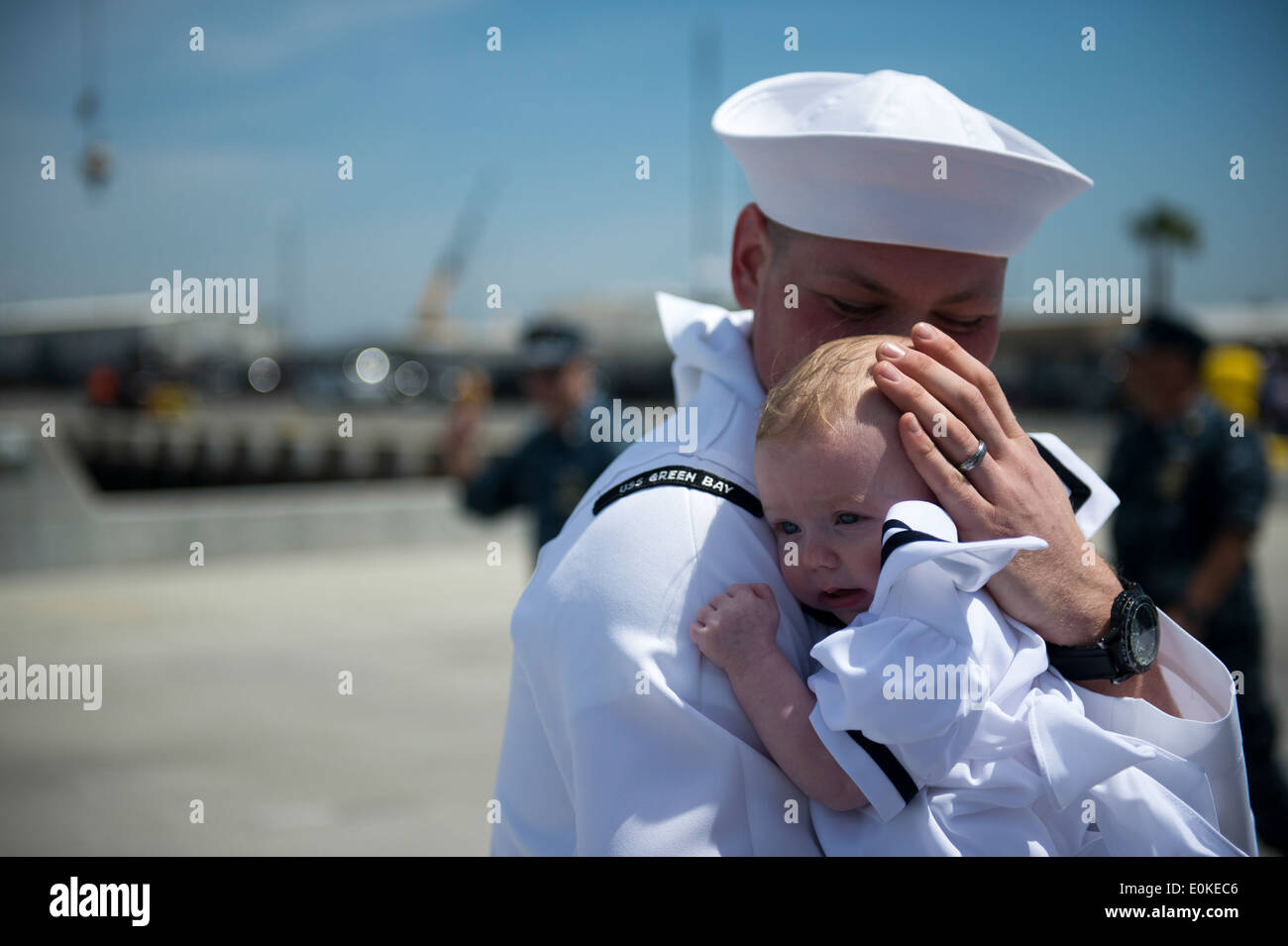 Un marinaio assegnato al trasporto anfibio dock nave USS Green Bay (LPD 20) abbraccia un bambino in un homecoming cerimonia alla Naval B Foto Stock