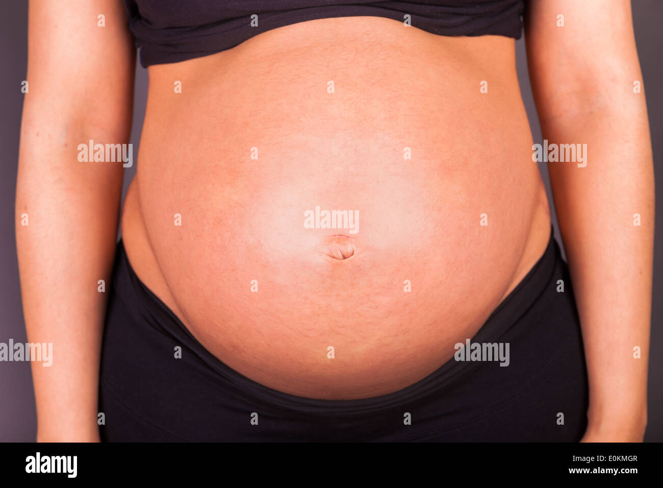 Giovani incinta Donna nero toccando il suo ventre.Close up Foto Stock