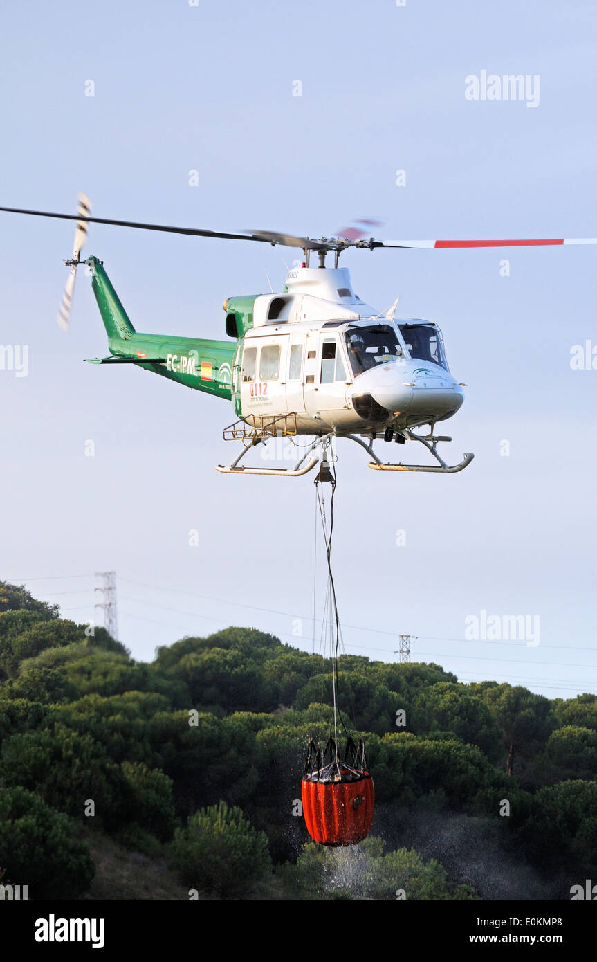 Bell 412 registrazione CE-IPM portando acqua per la lotta antincendio, Cabopino Golf, Costa del Sol, Spagna. Foto Stock