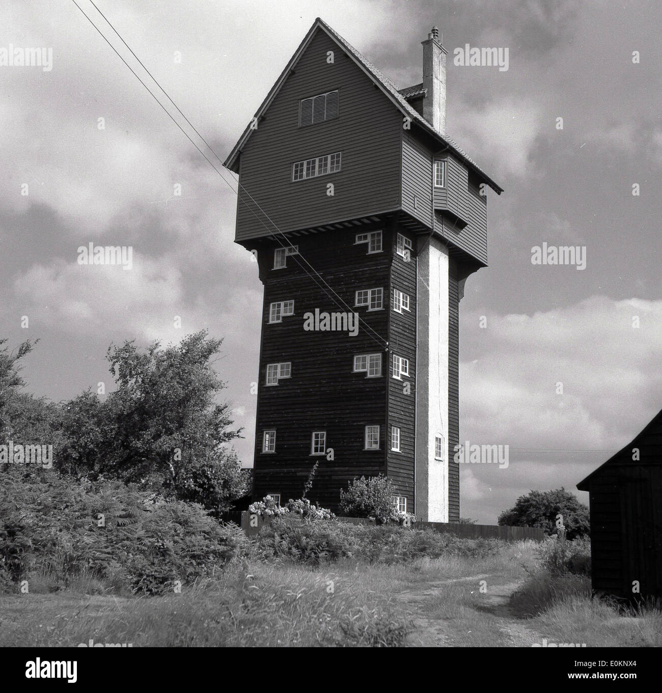 Degli anni Cinquanta, foto storiche dell'acqua torre a Thorpeness, Suffolk, Inghilterra. Costruito nel 1923 per ricevere l'acqua dal vicino mulino a vento, per migliorare il look della torre, il suo serbatoio è stato mascherato con la comparsa di un edificio weatherboarded in armonia con il villaggio di architettura. Negli anni settanta la torre fu completamente convertiti in una casa ed è conosciuta come la "Casa di Nuvole", come l'edificio è circa 70 ft alta. Foto Stock