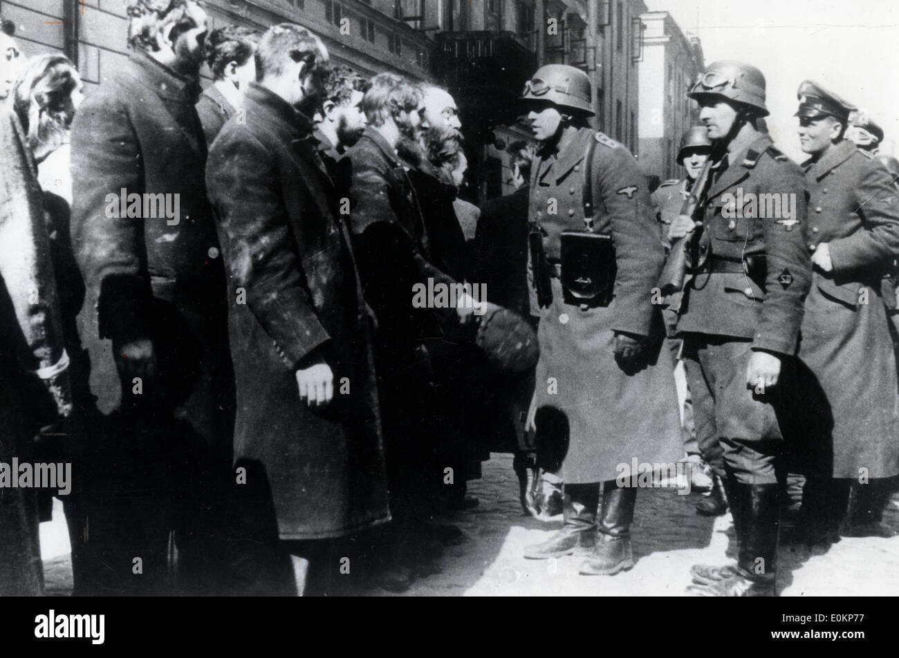 Gruppo di ebrei del ghetto di Varsavia sono interrogate da S.S. ufficiali prima della loro partenza per un campo di concentramento Foto Stock
