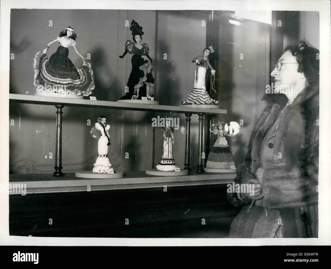 Il 12 Dic. 1951 - La Lilian Lunn figure in costume in mostra. Tiny bambole in mostra: una mostra di Lilian Lunn Costume figure in miniatura - viene trattenuto dalla Facoltà Internazionale delle Arti di 45 Park Lane. I modelli sono 150 piccole bambole, ciascuna di un piede alta, ricamati dalla sig.ra Lilian Lunn di Buxton, Derbyshire. Lei ha utilizzato più di 2.000 punti di cucitura su di essi. Esse sono tutte le repliche di persone famose. La foto mostra alcuni dei modelli unici tra cui ''Carmen Miranda'' - visto con il loro Creatore - Sig.ra Lilian Lunn cercando su questa mattina. Foto Stock