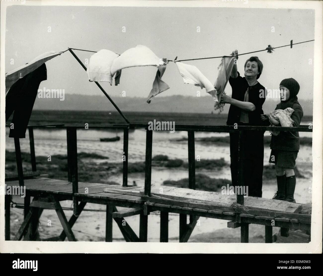 Febbraio 02, 1953 - Conseguenze dell'Essex inondazioni.. Appendere fuori il suo lavaggio sulla casa galleggiante. La signora Dorothy Prium e suo figlio Kars erano tra le poche persone che sono rimaste a Canvey Island durante l evacuazione principale.. La sig.ra Prium era responsabile per il salvataggio di molti dei suoi vicini che si rifugiarono in houseboat sulla quale vive... Keystone Mostra fotografica di:- Sig.ra Prium scende per il processo di lavaggio di vestiti - e si è visto come le appende fuori a secco - a Canvey. Foto Stock