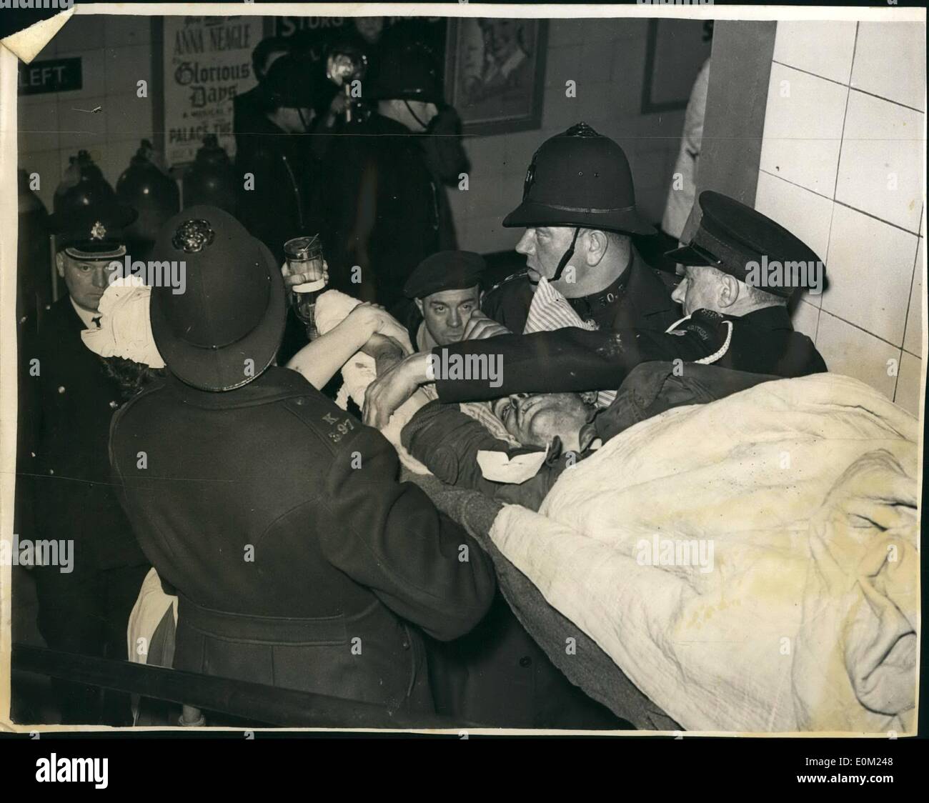 Apr. 04, 1953 - nove morti nel disastro del tubo: nove persone sono state oggi noti sono stati uccisi nella linea centrale del tubo di emergenza Stratford la notte scorsa la peggiore a Londra sotterraneo della storia. La foto mostra le dieci ore dopo il crash di poliziotti e di un ambulanza uomo portare uno dei feriti oggi. Foto Stock