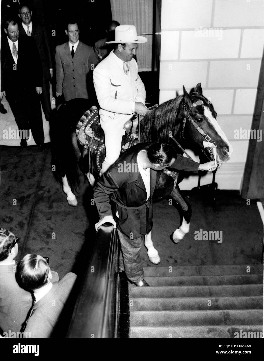 Un stableman cercando di guida Gene Autry e il suo cavallo su per le scale Foto Stock