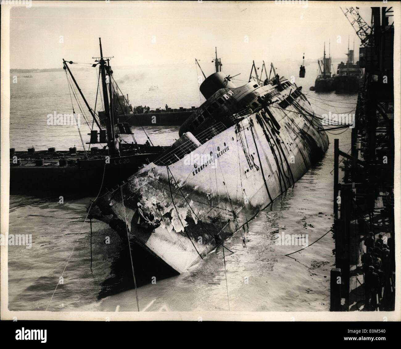 Agosto 08, 1953 - Il sollevamento del ''Kronprins Frederik''. Gli sforzi per elevare il sunken liner danese, ''Kronprins Frederik'', che si rovesciò ed affondò dopo essere stata spazzata via dai fuoco a Harwich, in aprile, vengono fatte oggi. Recuperare gli uomini hanno lavorato per mesi sulla nave e sono iniziati i lavori per il suo sollevamento. Keystone Mostra fotografica di:- iniziarono i lavori per preparare il sollevatore a 6.30 di questa mattina e questa è stata la scena a ore 10- che mostra due uomini di essere sollevato dalla nave in una benna, mediante gru. Foto Stock