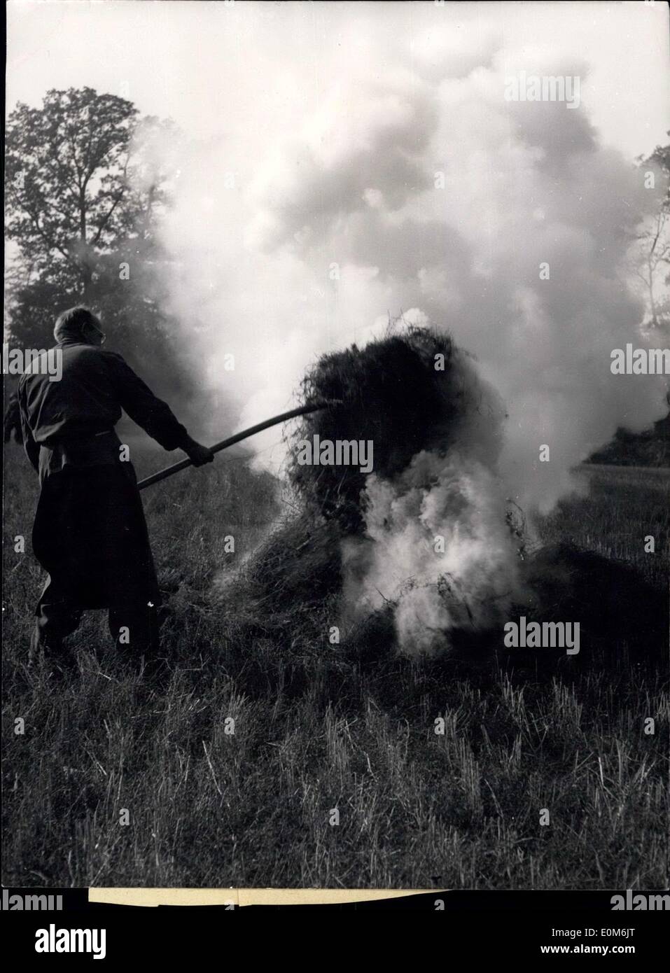 Ottobre 13, 1953 - Le nuvole scure sono in piedi a pale cielo di autunno. I resti del raccolto vengono bruciati sui campi e il vento autunnale porta il Shaggy al di sopra delle stoppie-campi. Foto Stock