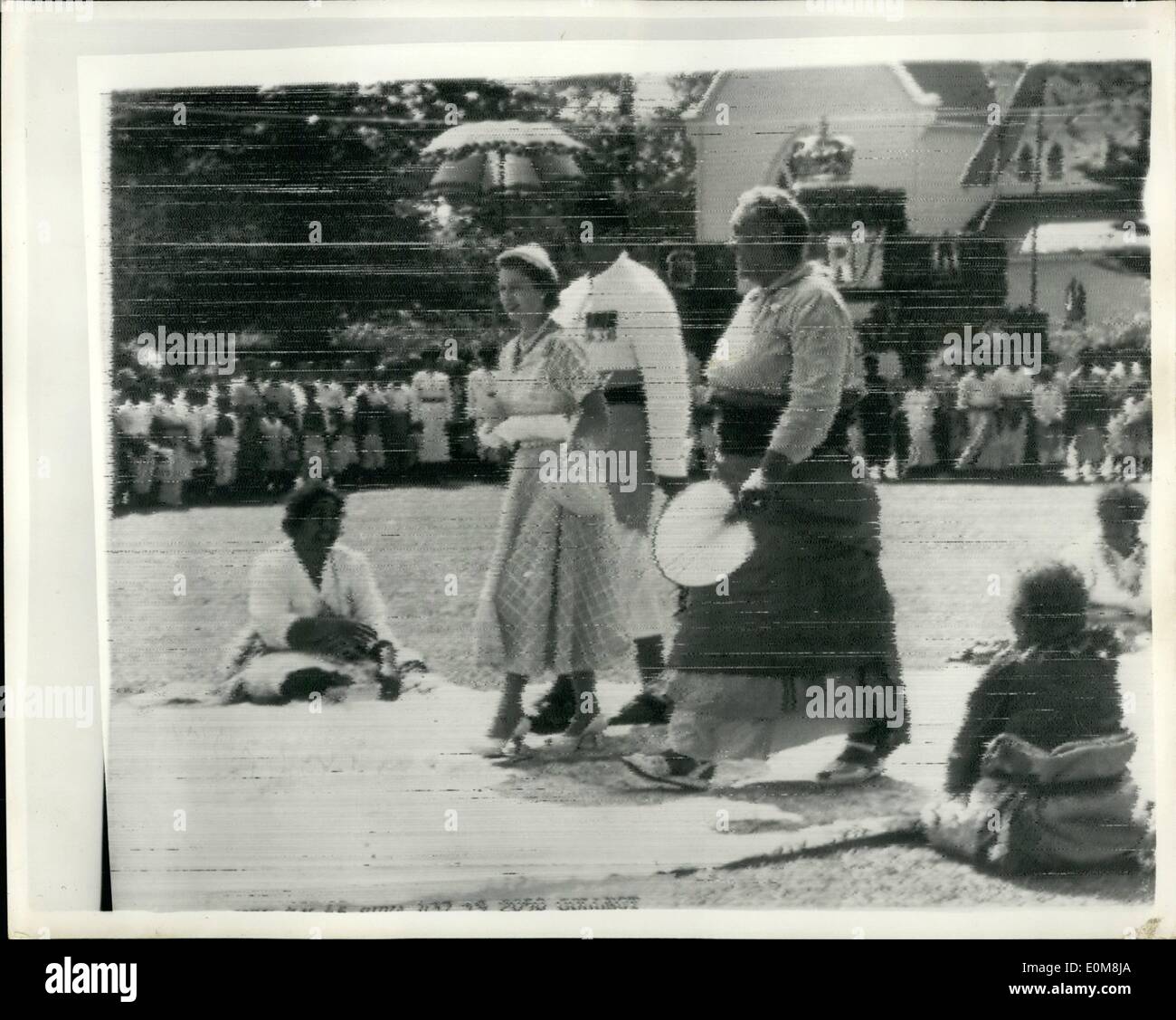 Il 12 Dic. 1953 - Queen Elizabeth arriva in Tonga: Queen Elizabeth ha continuato la sua Royal Tour arrivò a Tonga da Suva, Figi, è stata una giornata di tifo, danze e banchetti. Tonga è fantastico benvenuto è iniziato con due mondiali del Regina regnante la condivisione di uno scherzo che ha iniziato sulla baia di incoronazione. Come la regina e il torreggiante Regina Salote ha spinto fuori dal pontile fastooned una nuvola inviato in una ''Token'', doccia, un ricordo dolce di incoronazione il giorno. La foto mostra la regina coperto da un ombrellone a causa della pioggia che ha salutato la lascia il pontile con letto Queen Salote sul suo arrivo in Tonga. Foto Stock