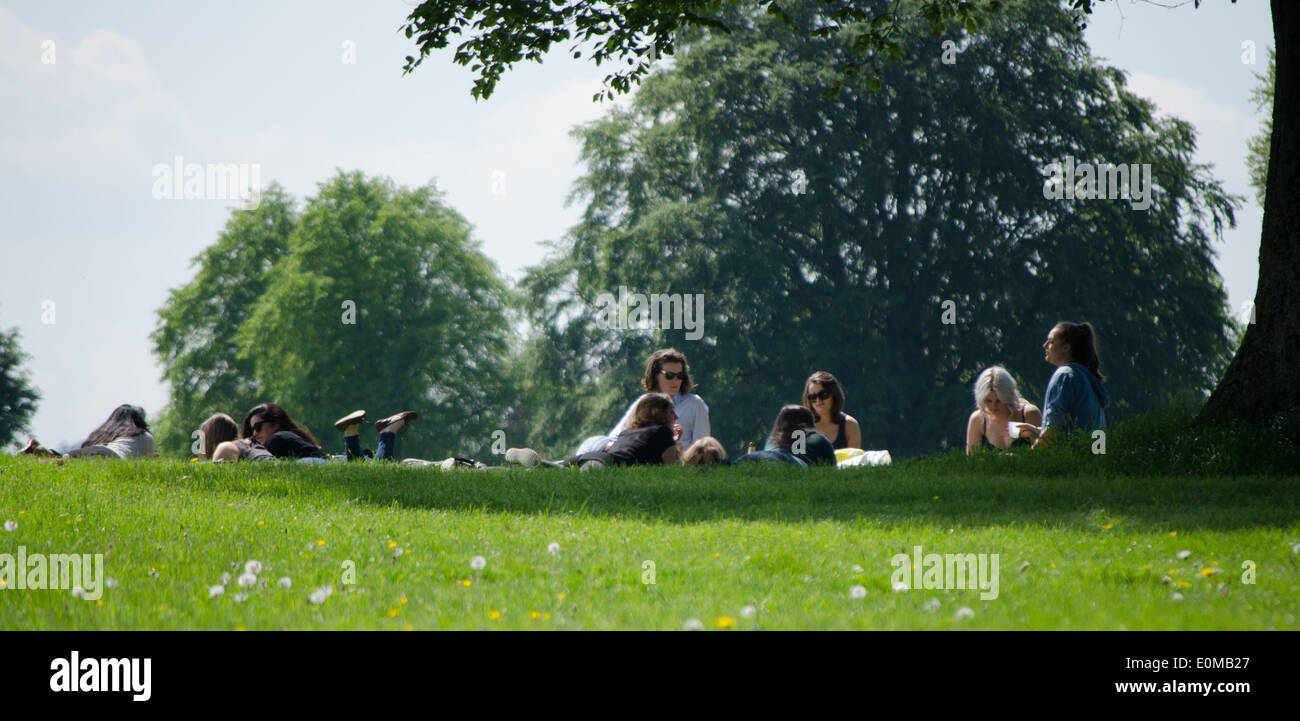 Persone lounging circa in un parco al sole Foto Stock
