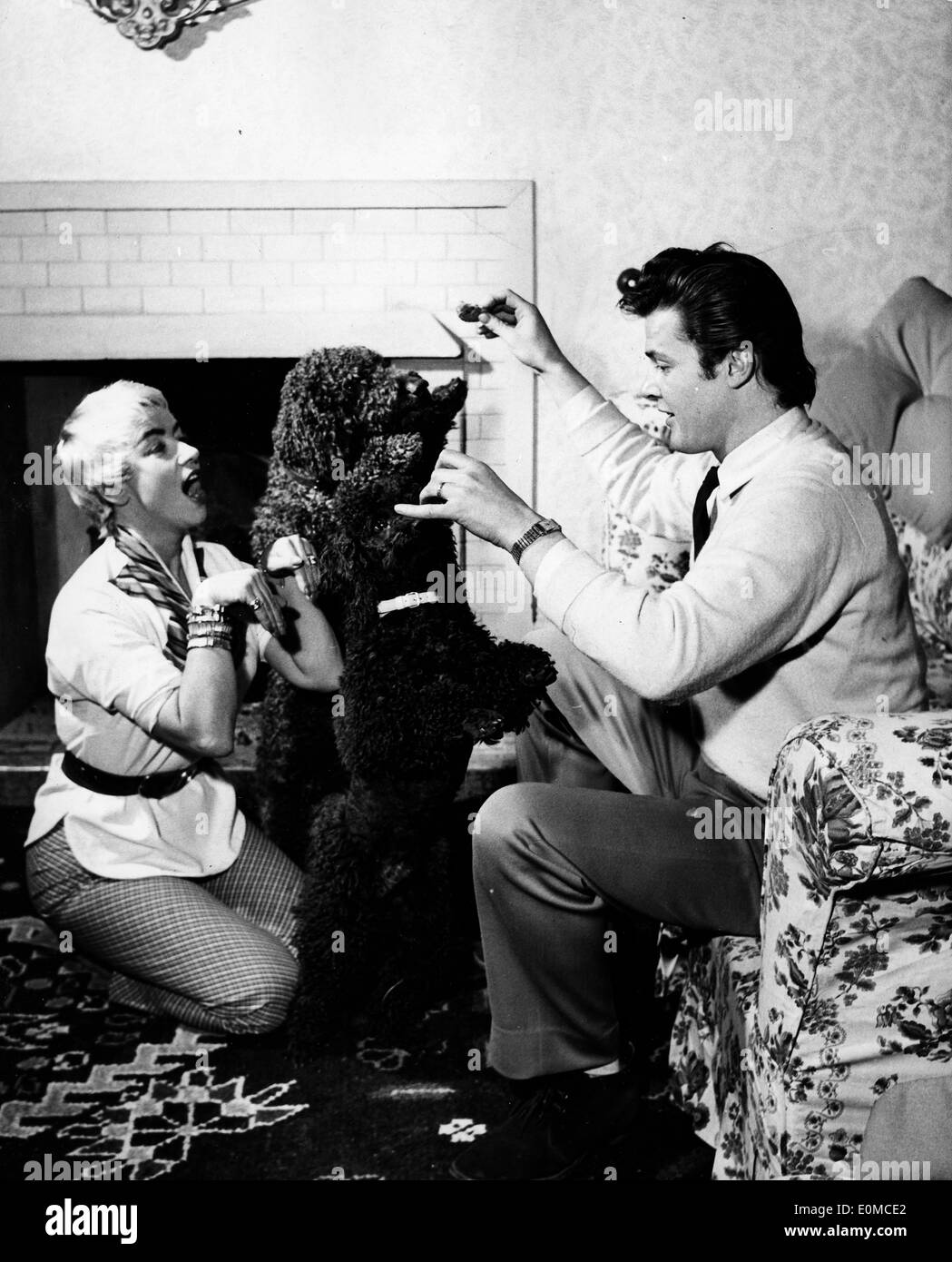 Attore Roger Moore e la moglie Dorothy Squires giocando con i loro cani Foto Stock