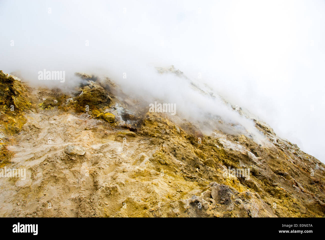 Sulla sommità del vulcano Etna il rock è coperto con zolfo e diventa gialla, nube di gas tossico diffuso dal cratere Foto Stock