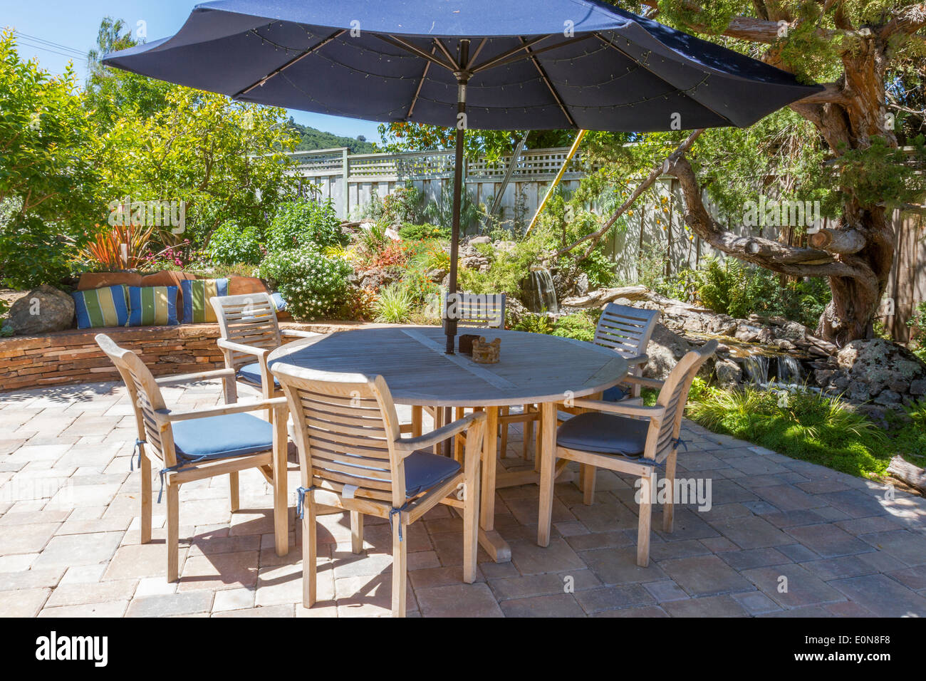 Bellissimo cortile paesaggistico con acqua di ruscello dispongono di patio dietro il tavolo da pranzo Foto Stock