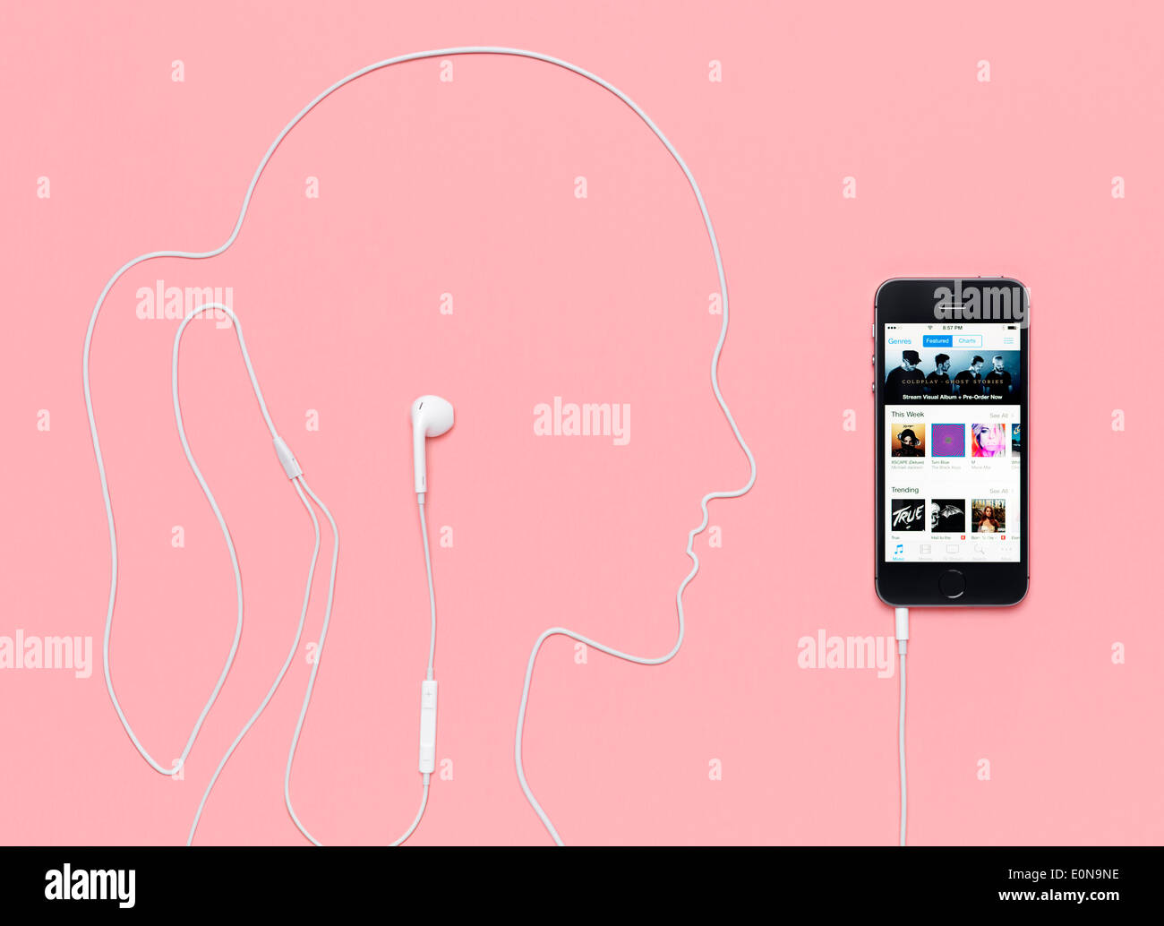 Testa di donna, fatta di contorno da un cavo cuffie inserito in iPhone 5s smartphone con iTunes Music Store sul suo display. Foto Stock