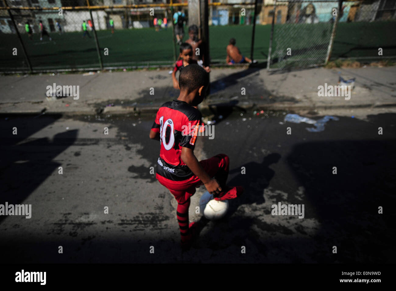 RIO DE JANEIRO, Brasile - 16 Maggio: i bambini che giocano a calcio in New Holland complesso di baraccopoli Mare Zona Nord della città. baraccopoli in Brasile, la maggior parte spesso in aree urbane. Il primo favelas o "lum' apparve nel tardo XIX secolo e sono state costruite dai soldati che non avevano nulla a vivere. Alcuni dei primi insediamenti furono chiamati bairros africanos (quartieri africani). Questo era il luogo in cui ex schiavi con n. di proprietà fondiaria e nessuna opzione per il lavoro vissuto. Nel corso degli anni molti ex schiavi neri spostato in. Foto di Fabio Teixeira / Pacific Stampa) Foto Stock