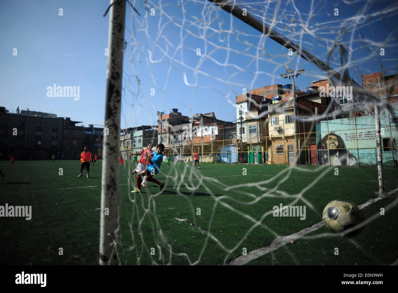 RIO DE JANEIRO, Brasile - 16 Maggio: i bambini che giocano a calcio in New Holland complesso di baraccopoli Mare Zona Nord della città. baraccopoli in Brasile, la maggior parte spesso in aree urbane. Il primo favelas o "lum' apparve nel tardo XIX secolo e sono state costruite dai soldati che non avevano nulla a vivere. Alcuni dei primi insediamenti furono chiamati bairros africanos (quartieri africani). Questo era il luogo in cui ex schiavi con n. di proprietà fondiaria e nessuna opzione per il lavoro vissuto. Nel corso degli anni molti ex schiavi neri spostato in. Foto di Fabio Teixeira / Pacific Stampa) Foto Stock