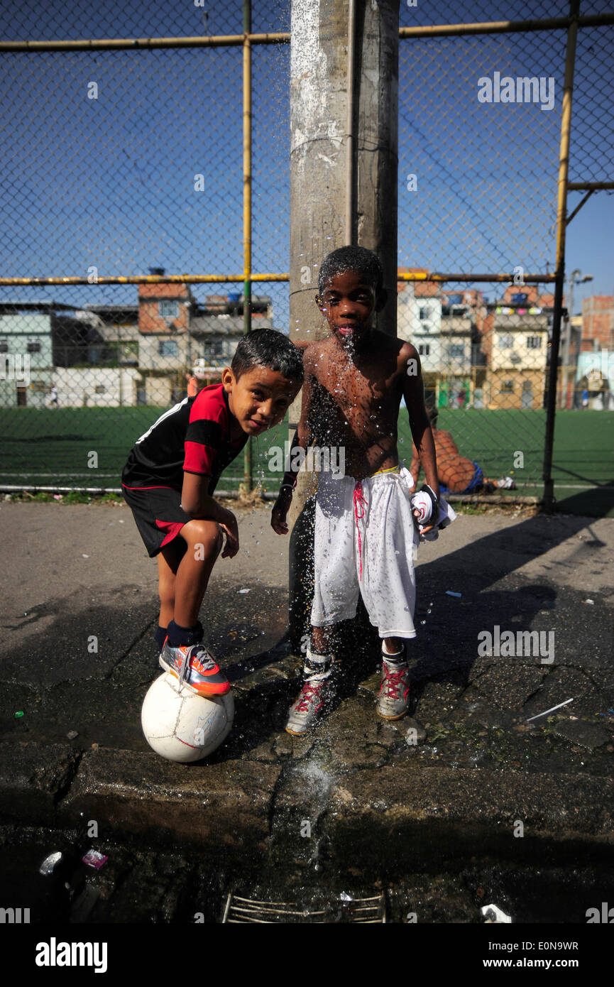RIO DE JANEIRO, Brasile - 16 Maggio: i bambini che giocano a calcio in New Holland complesso di baraccopoli Mare Zona Nord della città. baraccopoli in Brasile, la maggior parte spesso in aree urbane. Il primo favelas o "lum' apparve nel tardo XIX secolo e sono state costruite dai soldati che non avevano nulla a vivere. Alcuni dei primi insediamenti furono chiamati bairros africanos (quartieri africani). Questo era il luogo in cui ex schiavi con n. di proprietà fondiaria e nessuna opzione per il lavoro vissuto. Nel corso degli anni molti ex schiavi neri spostato in. Foto di Fabio Teixeira / Pacific Stampa) Foto Stock