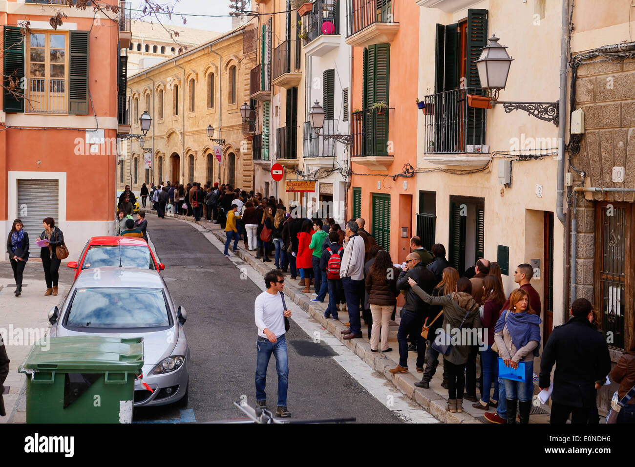 La gente in attesa al di fuori di una impresa che offre 120 posti di lavoro temporanei nell'isola di Maiorca, SPAGNA Foto Stock