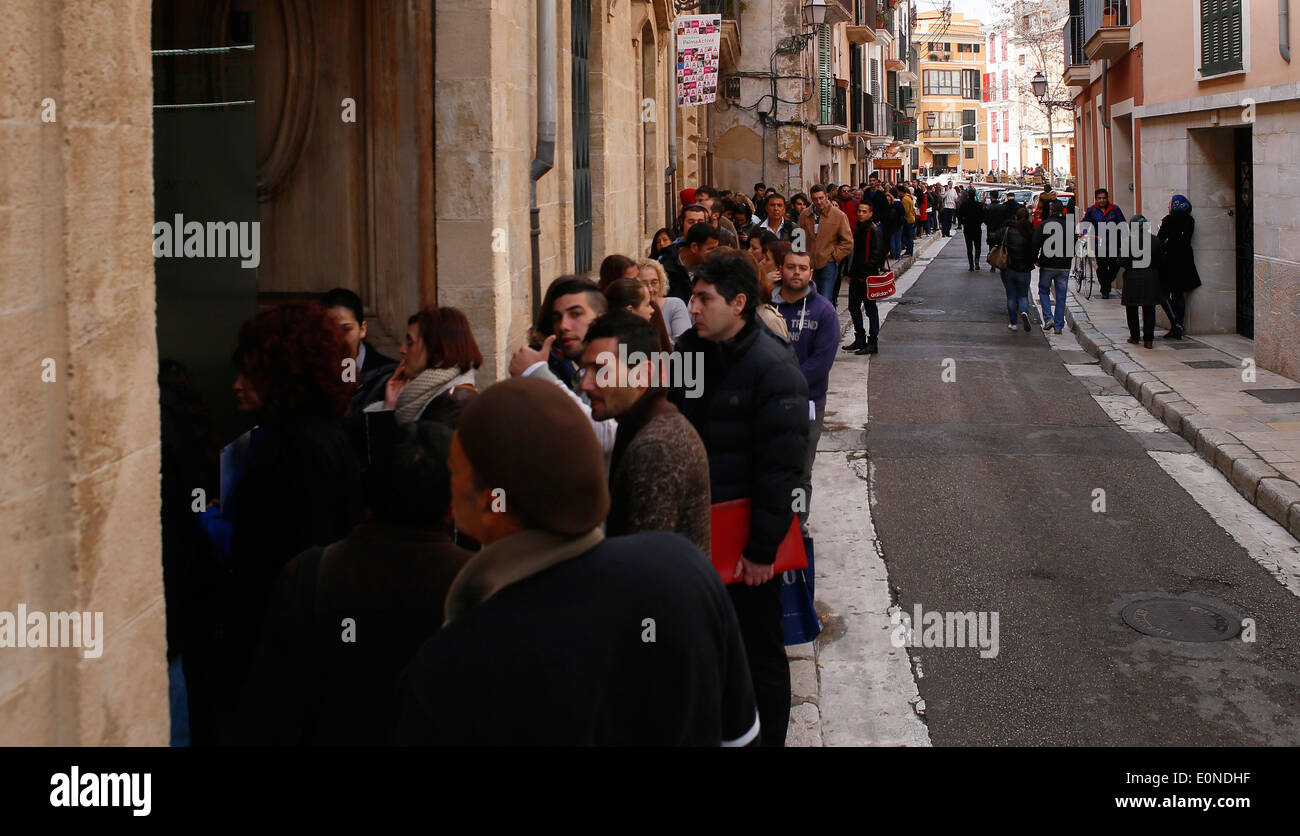 La gente in attesa al di fuori di una impresa che offre 120 posti di lavoro temporanei nell'isola di Maiorca, SPAGNA Foto Stock