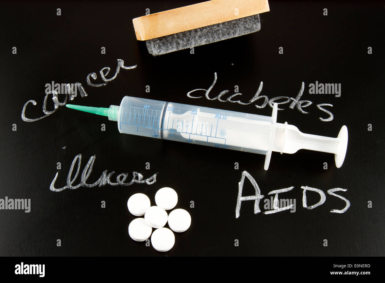 Parole il cancro, il diabete, l'AIDS e malattie scritti su una lavagna con un raschietto, siringa e pillole Foto Stock