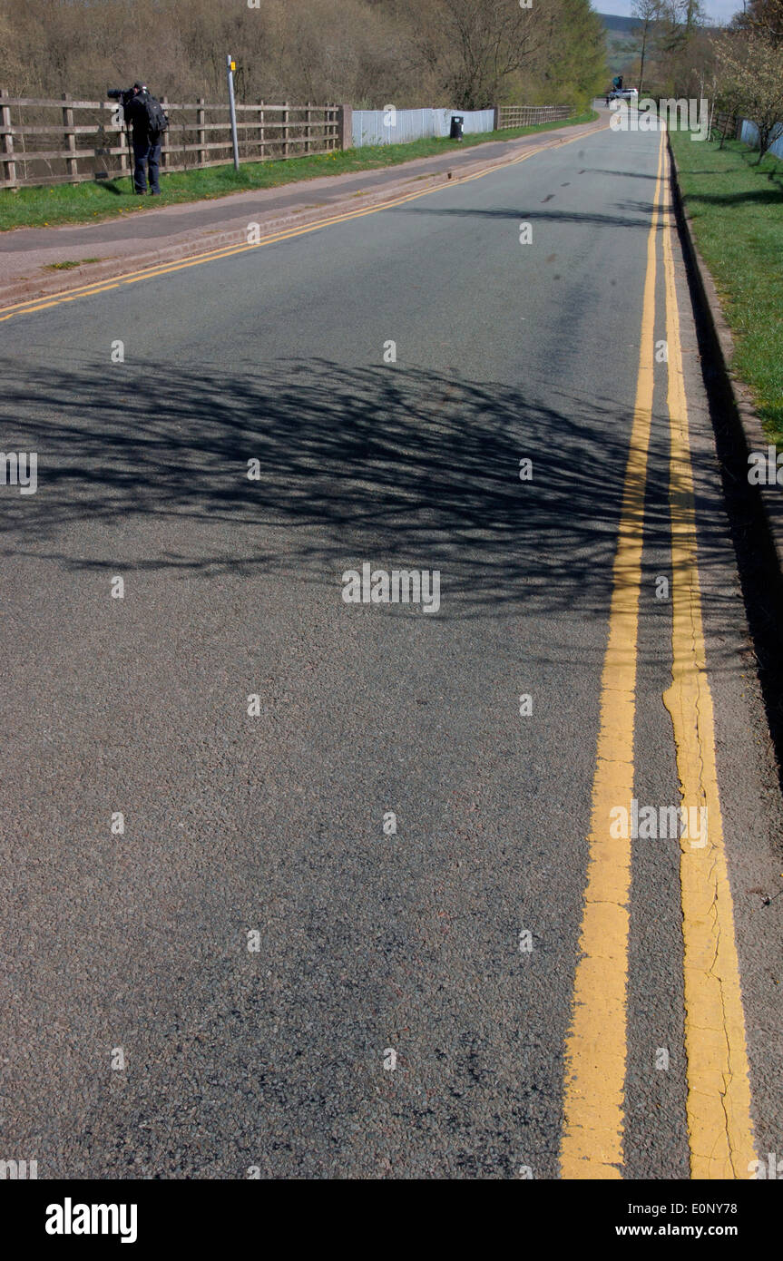 Doppio giallo le linee,l'esecuzione fino ad una strada. Foto Stock