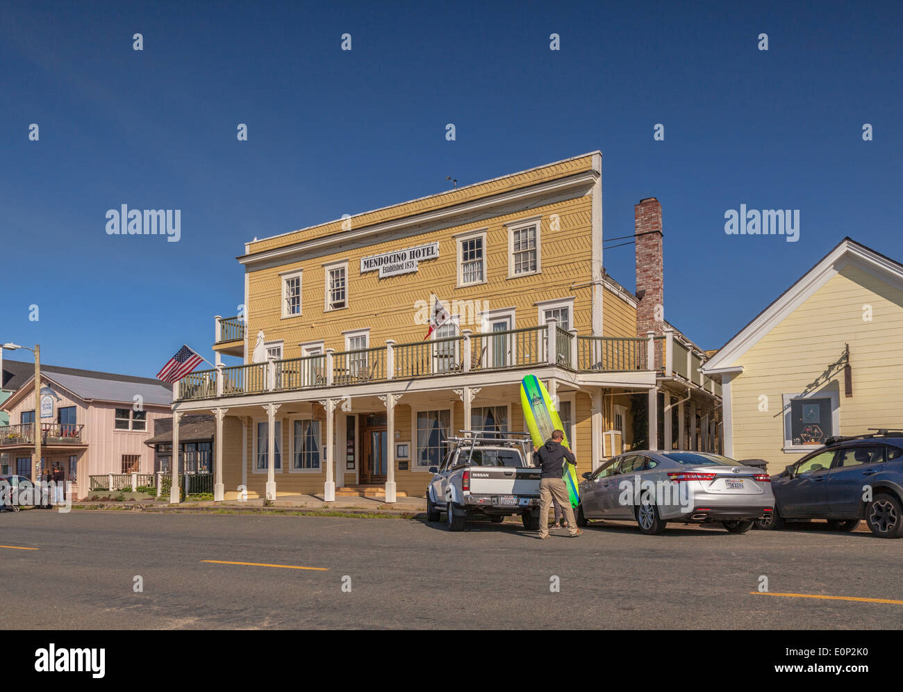 Mendocino Hotel, mendocino, Mendocino County, California. Un uomo manouevres una tavola da surf da un carrello di prelievo. Foto Stock