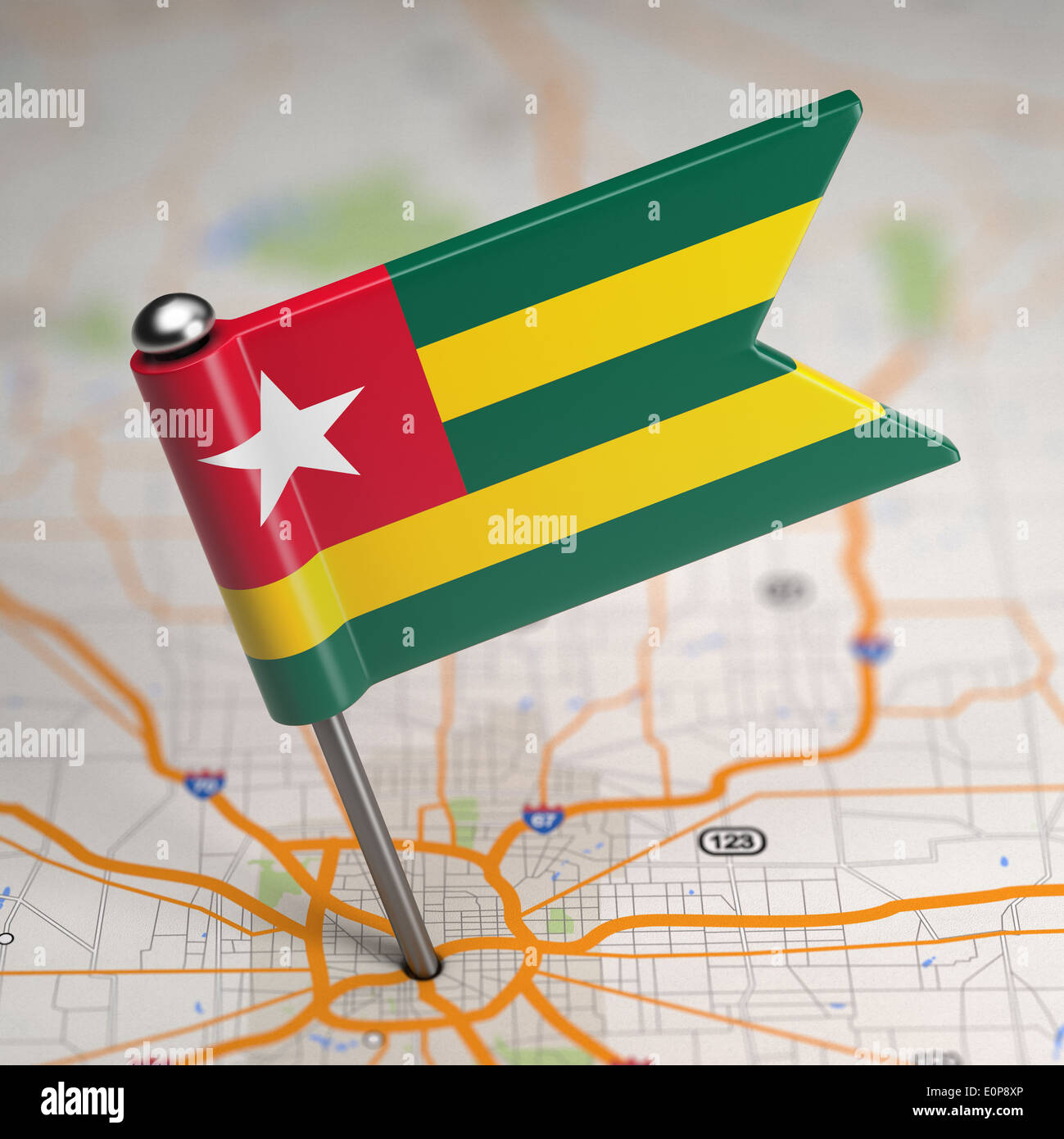 Piccola Bandiera Repubblica Togolese su uno sfondo raffigurante una mappa con il fuoco selettivo. Foto Stock