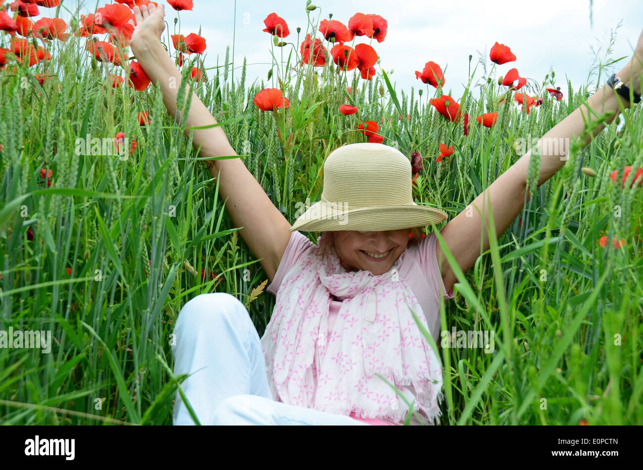 Donna con cappello seduti sul prato Foto Stock