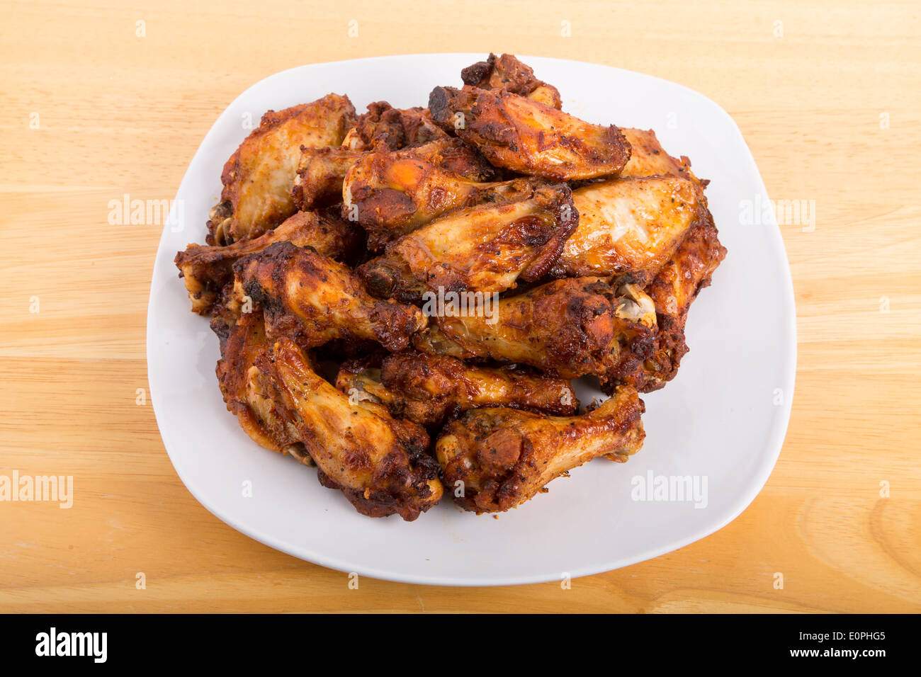 Alette di pollo fritte con salsa di mesquite su una piastra bianca Foto Stock