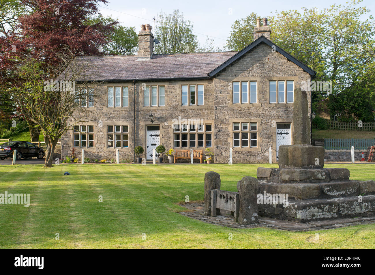 Vecchie scorte e il XIII secolo croce di pietra verde villaggio Bolton-da-Bowland, Lancashire, Inghilterra, Regno Unito Foto Stock