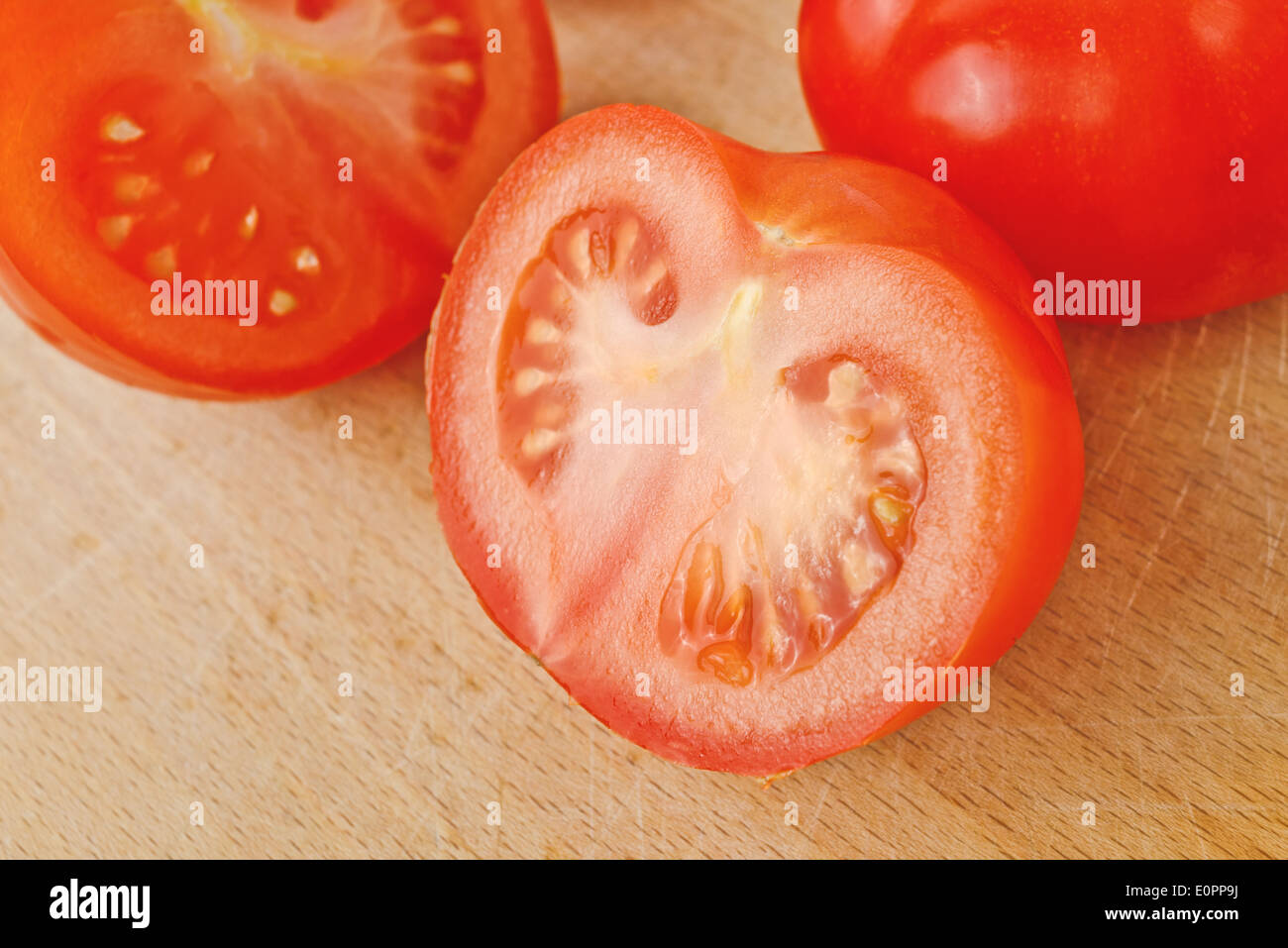 Pomodori freschi maturi con halfs sulla tavola di legno, gustose verdure biologiche per mangiare sano. Foto Stock
