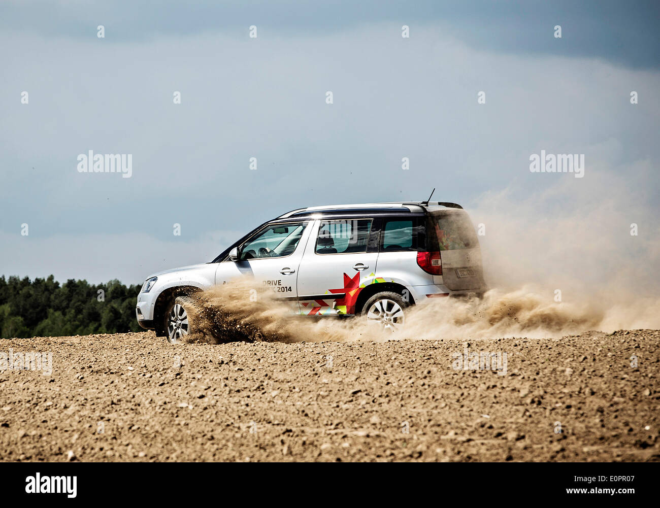 Un SUV con i giornalisti scorre attraverso un campo per visualizzare una gigantesca statua di bielorusso simbolo nazionale, il Bisonte Europeo, su una autostrada che conduce a Minsk, Bielorussia, Sabato, Maggio 10th, 2014. Le autostrade in Bielorussia non conformi con West norme europee. Western Foto Stock