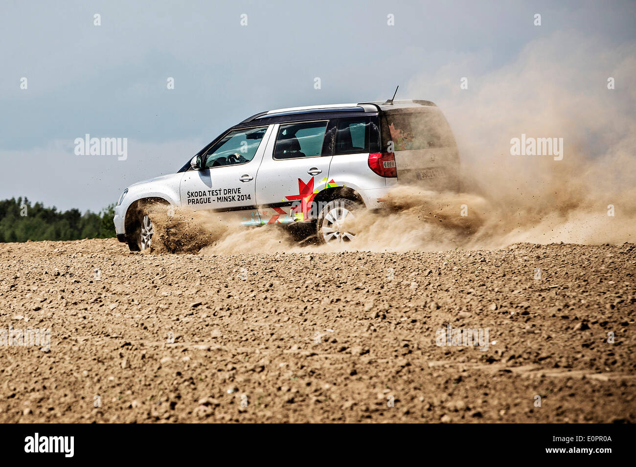 Un SUV con i giornalisti scorre attraverso un campo per visualizzare una gigantesca statua di bielorusso simbolo nazionale, il Bisonte Europeo, su una autostrada che conduce a Minsk, Bielorussia, Sabato, Maggio 10th, 2014. Le autostrade in Bielorussia non conformi con West norme europee. Western Foto Stock