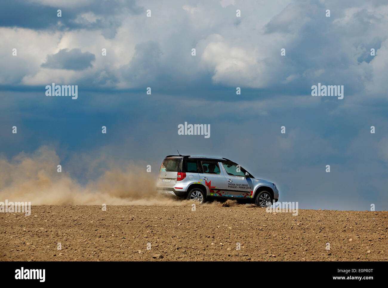 Un SUV con i giornalisti scorre attraverso un campo per visualizzare una gigantesca statua di bielorusso simbolo nazionale, il Bisonte Europeo, su una autostrada che conduce a Minsk, Bielorussia, Sabato, Maggio 10th, 2014. Le autostrade in Bielorussia non conformi con West norme europee. Western Foto Stock