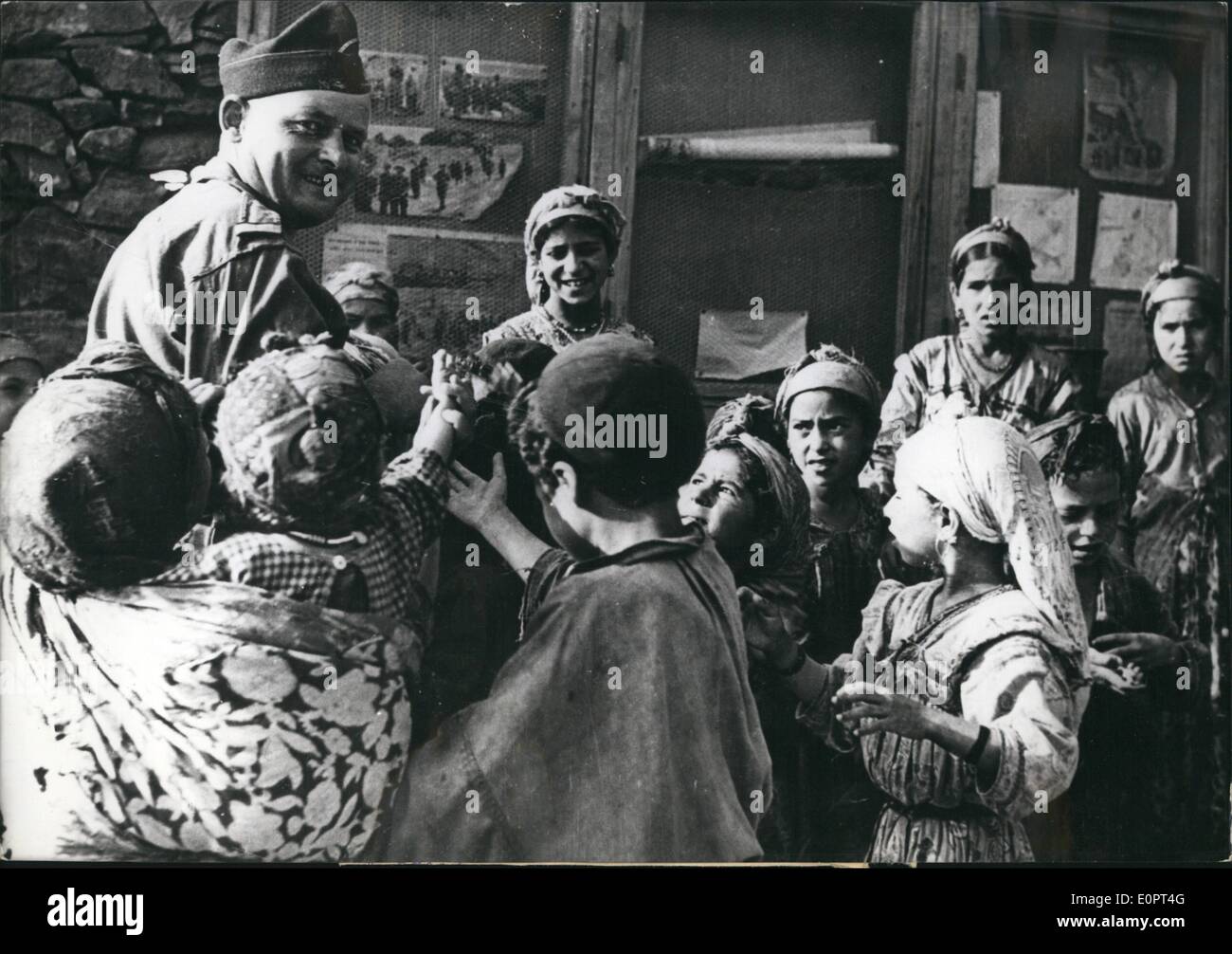 Febbraio 02, 1957 - non la guerra in Algeria. OPS: un soldato francese distribuendo caramelle ai bambini nativi a Beni Ouazedine, un piccolo villaggio algerino. Foto Stock
