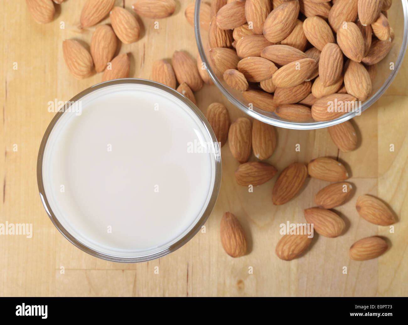 Latte di Mandorla come un sostituto per il latte fresco. Un bicchiere di latte di mandorla e mandorle su di un tavolo di legno. Foto Stock