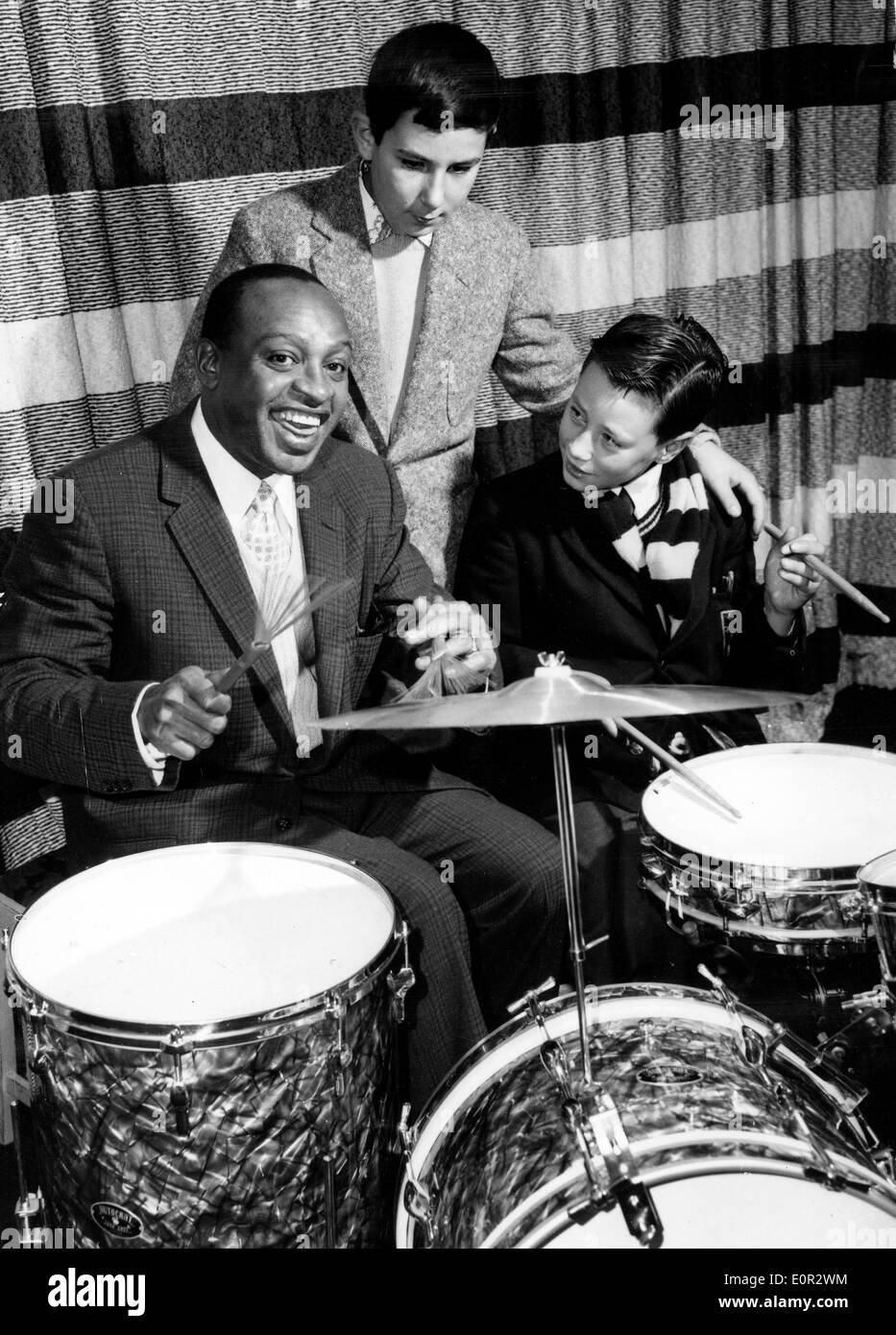 Il cantante Lionel Hampton insegna i ragazzi della scuola come suona la batteria Foto Stock