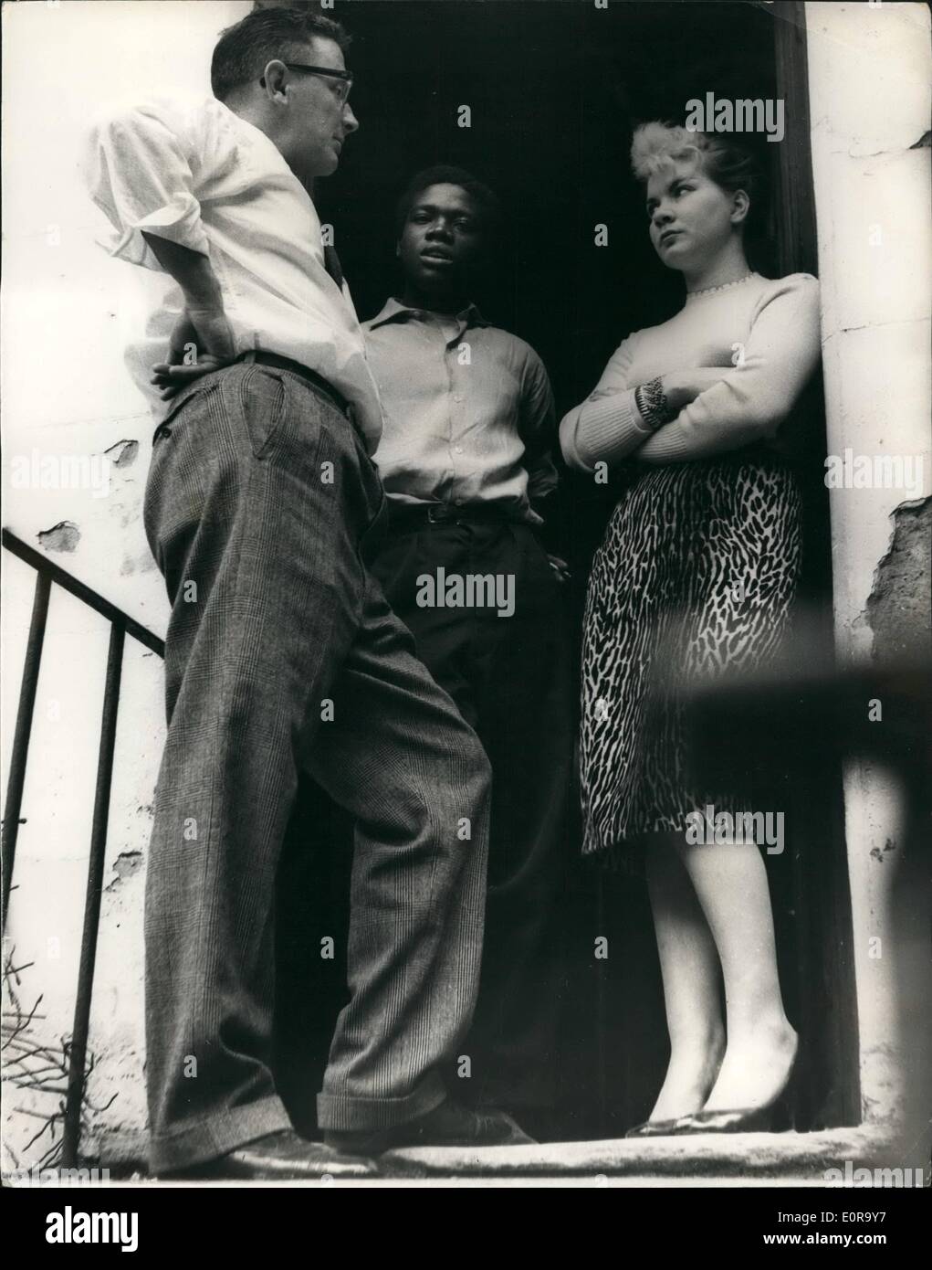 Sett. 09, 1958 - nero v. White tumulti in London Notting Hill: Per la terza notte in successione i tumulti tra il bianco e il nero di persone ha avuto luogo la scorsa notte a Londra Notting Hill. Sia in bianco e nero di persone vivono nella paura. Pattuglia di polizia nella zona in coppie. mantenendo le due fazioni apart. La foto mostra un reporter parla di Giosia colorati Taylor e la ragazza in bianco sui gradini di una casa a Notting Hill come egli lega per trovare la vera causa del problema tra il nero e il bianco popolo. Foto Stock