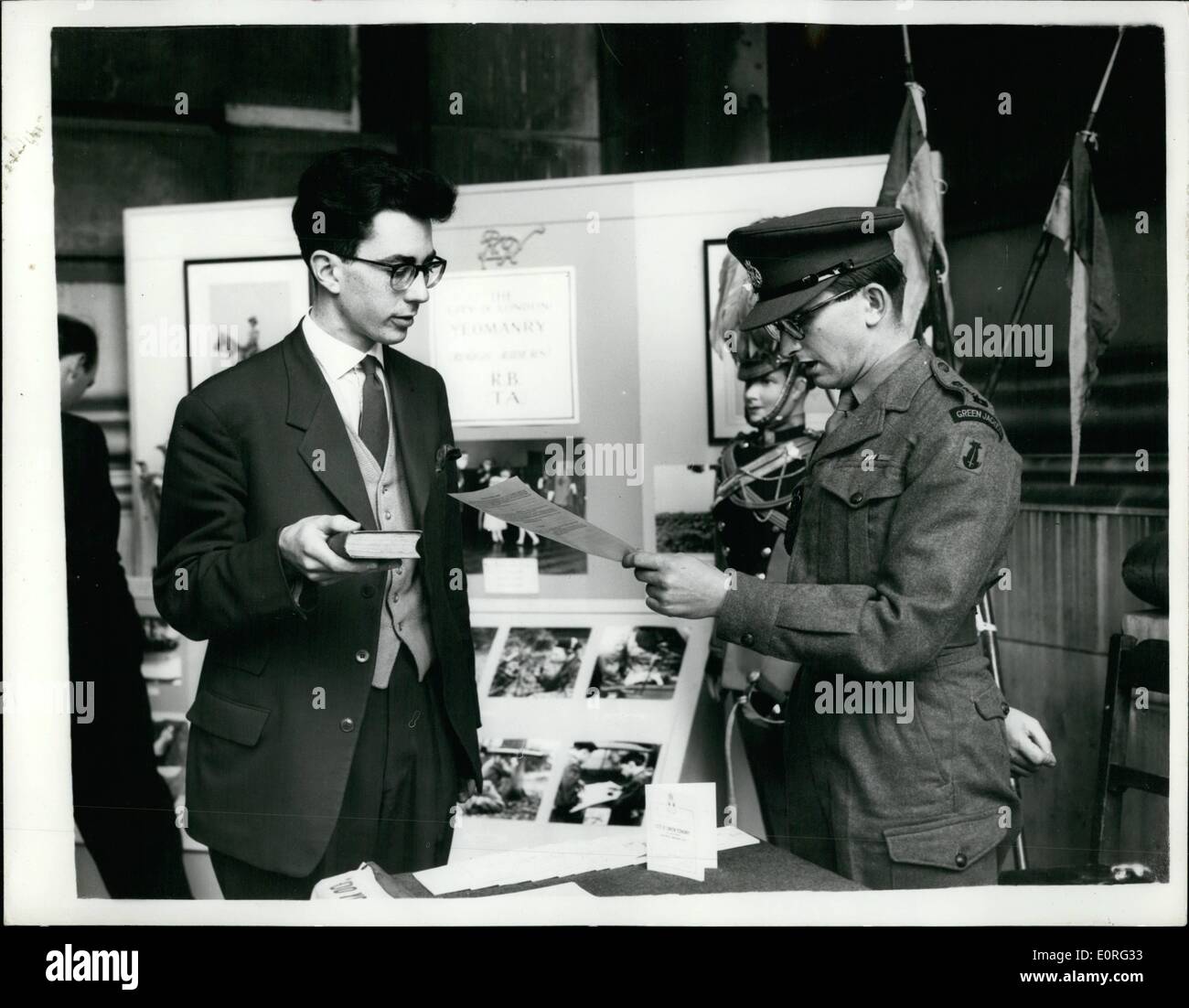 05 maggio 1959 - Sunshine arruolamento reclutare territoriale prende il giuramento in Royal Exchange fasi: Sunshine - e un display di reclutamento sui gradini della Royal Exchange - sta portando reclute per la City Of London Yeomanry, (ruvido piloti) TA. Dopo aver ispezionato il display delle armi da fuoco e le foto delle attività del reggimento, 20-anno-vecchio Michael John fino a, è stato giurato sul posto mediante una grossolana del ciclista, aiutante Capt. P. Trustram Eve. Foto Stock