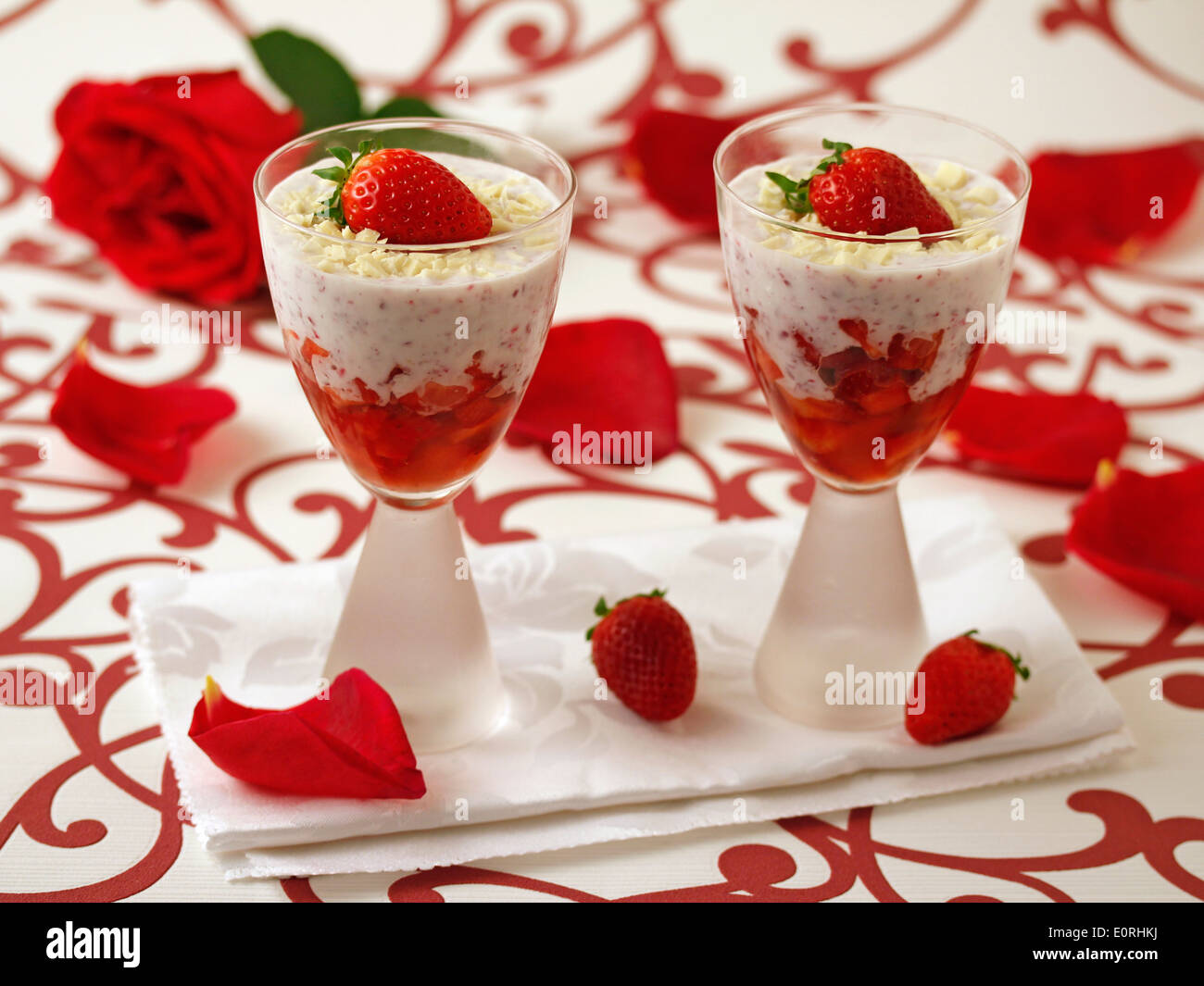 Fragole con yogurt e rose. Ricetta disponibile. Foto Stock