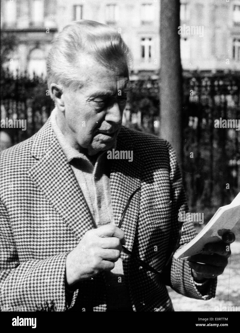 Attore Victor Francen percorrendo a piedi il marciapiede la lettura Foto Stock